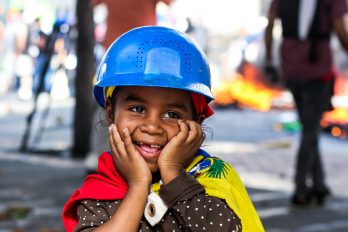 Una niña sonríe en medio del caos de las protestas en Venezuela